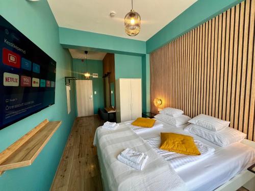 a bedroom with a large white bed with yellow pillows at Boutique Hotel & Event Center in Budapest