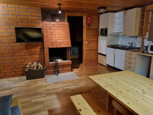 uma cozinha com uma lareira de tijolos num quarto em Ylläs Valokki em Ylläsjärvi