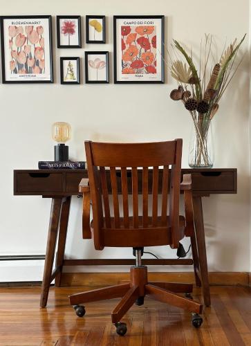 a wooden desk with a chair and a table with a vase at Downtown New Haven by Yale & Little Italy - AO Destinations in New Haven
