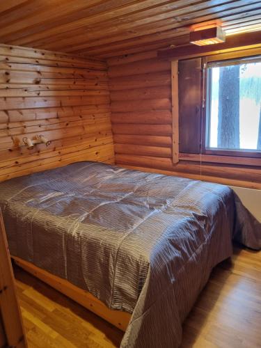 um quarto com uma cama num chalé de madeira em Ylläs Valokki em Ylläsjärvi