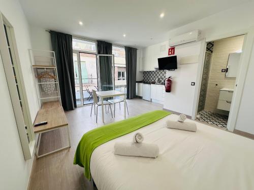 1 dormitorio con 1 cama grande con manta verde en Rainbow Apartments BY BLAUSITGES, en Sitges