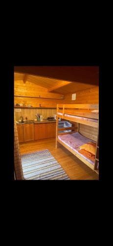 a room with a bunk bed and a kitchen at Домик на берегу Чудского озера in Katase