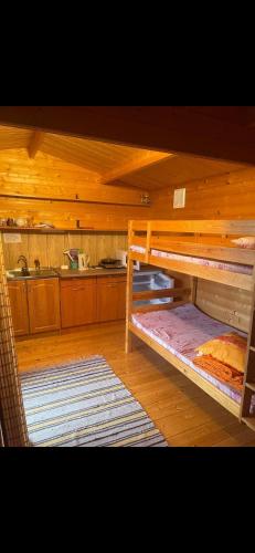 a room with two bunk beds and a kitchen at Домик на берегу Чудского озера in Katase