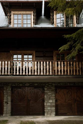 a house with wooden doors and a balcony at Artist's House in Falsztyn