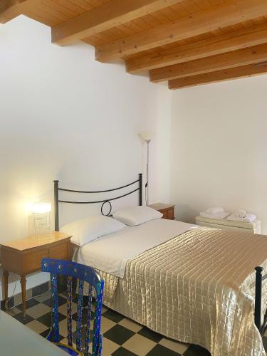 a bedroom with a bed and a blue chair at Pantalica Rooms Affittacamere Sortino Siracusa in Sortino