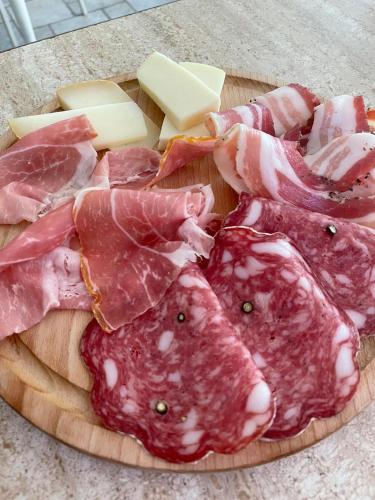 a plate of meat and cheese on a cutting board at Hotel Le Colline in San Gimignano