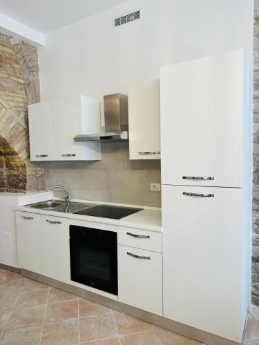 a kitchen with white cabinets and a sink at Giulivi Assisi Apartments in Assisi