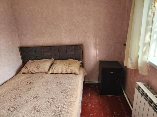 een slaapkamer met een bed, een tafel en een raam bij Guesthouse TTT-1 in Tbilisi City