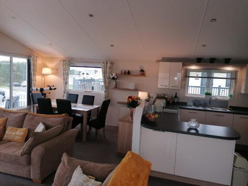 a kitchen and living room with a couch and a table at Lovely 3-Bed Lodge in Eyemouth with stunning views in Eyemouth