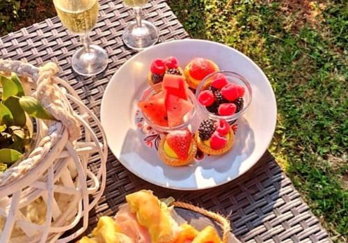 einen Obstteller auf einem Tisch mit Weingläsern in der Unterkunft Villa Mattei in Villa Pedergnano