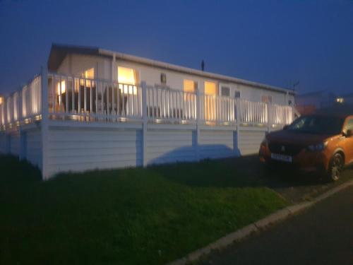 a house with a car parked in front of it at 3-Bed Lodge with SeaView-Fireplace-Garden-FreeP in Eyemouth