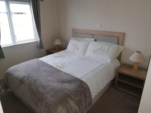 a bedroom with a large bed with two night stands at Lovely 3-Bed Lodge in Eyemouth with stunning views in Eyemouth