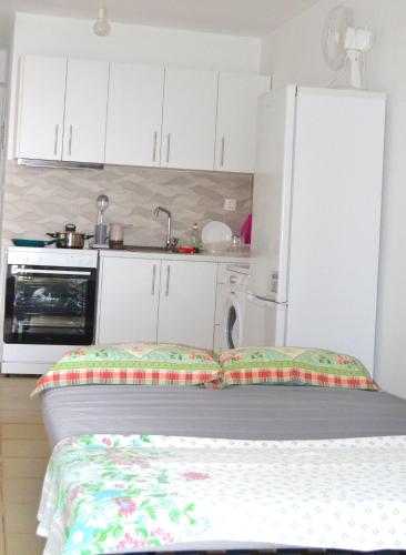 a kitchen with white cabinets and a bed in a room at Heavenly place in Possidi