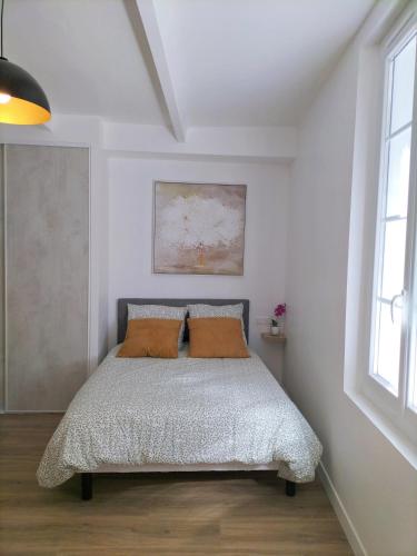 a bedroom with a bed with two pillows on it at Studio climatisé intra muros balcon in Avignon
