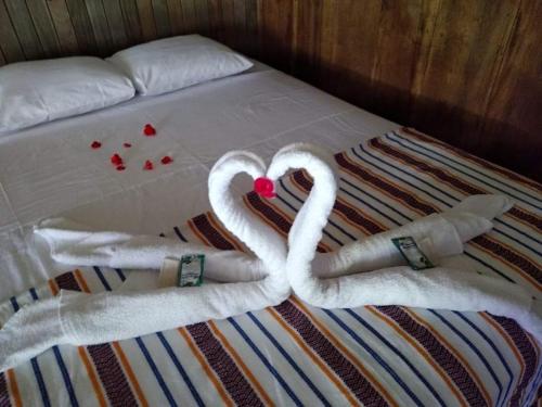 2 cygnes faits de serviettes sur un lit dans l'établissement Casa Maya, à La Viña