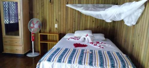 a bedroom with a bed with towels and a fan at Casa Maya in La Viña