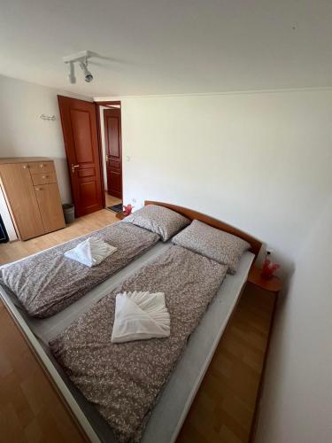 a bed in a bedroom with two pillows on it at Nyugalom Szigete Vendégház in Bócsa