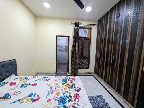 a bedroom with a bed with a floral bedspread on it at Excellent Home Away from Home! in Noida