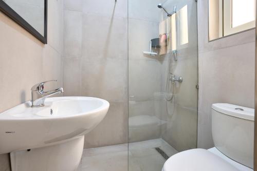 uma casa de banho com um lavatório, um WC e um chuveiro em Seafront Apartment in Xemxija em St. Paul's Bay