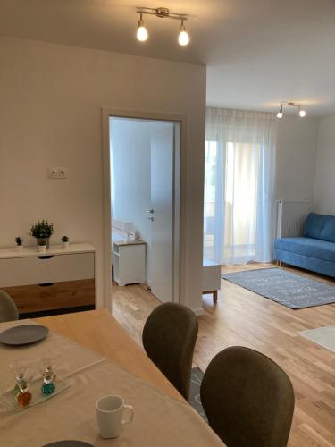 a living room with a table and a blue couch at Apartman Leo in Klinča Sela