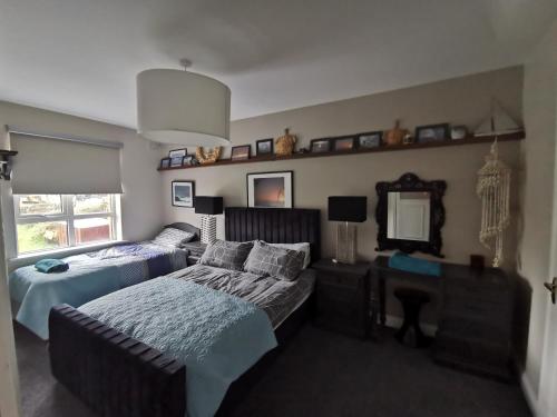 a bedroom with two beds and a mirror at Seashell Cove Bundoran Luxurious Sea View Free Wifi Netflix Sleeps 5 in Bundoran