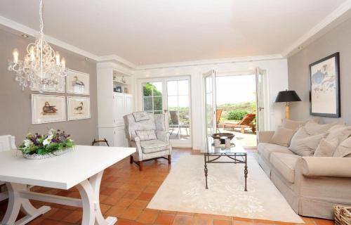 ein Wohnzimmer mit einem Sofa und einem Tisch in der Unterkunft Ferienwohnung für 3 Personen ca 90 m in Munkmarsch, Nordfriesische Inseln Sylt in Munkmarsch