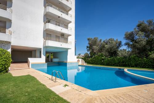 a swimming pool in front of a building at Holiferias Amoreira Mar in Alvor