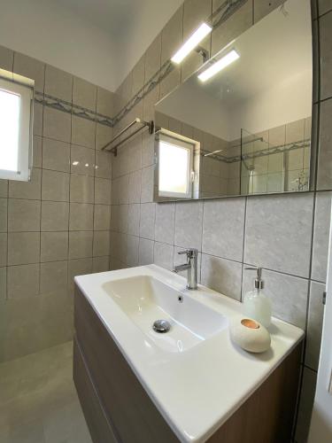 a white bathroom with a sink and a mirror at TheasHomly in Kastanéa