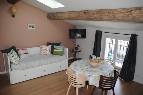 1 dormitorio con 1 cama y 1 mesa con sillas en Appartement cosy au deuxième étage, en Malaucène