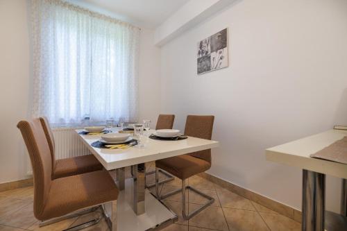 uma sala de jantar com uma mesa branca e cadeiras em Ferienwohnung für 4 Personen ca 65 qm in Njivice, Kvarner Bucht Krk em Njivice