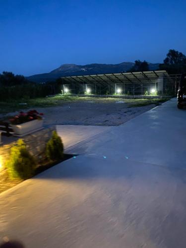 a parking lot with a building in the background at night at ΙΣΟΓΕΙΟ ΕΠΙΠΛΩΜΕΝΟ ΔΙΑΜΕΡΙΣΜΑ in Dhirrévmata
