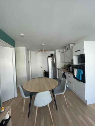 a kitchen with a table and chairs in a room at Appartement confort in Garches