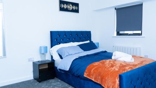 um quarto com uma cama azul e uma cabeceira azul em 1BR Sleeps 4, 3 mins from City centre & Local Gems em Burton upon Trent