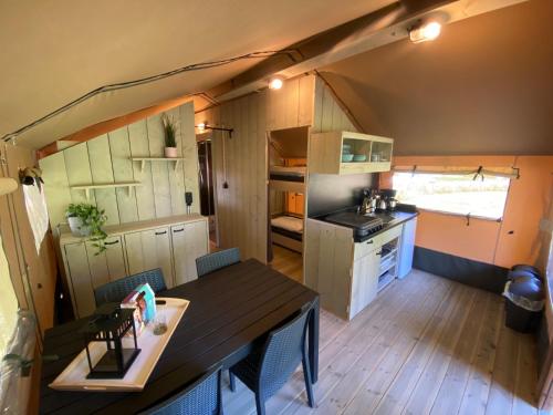 - une petite cuisine et une table à manger dans une petite maison dans l'établissement Camping Dun-le-Palestel, à Dun-le-Palestel