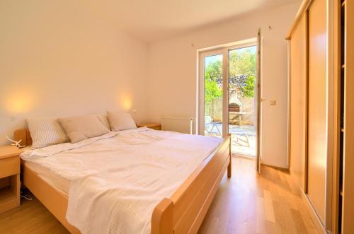 een slaapkamer met een groot bed en een glazen schuifdeur bij Happy Point in Krk