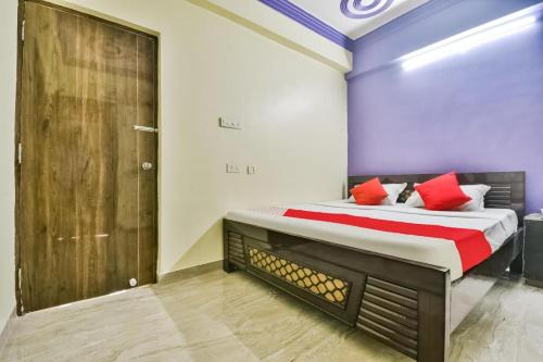 ein Schlafzimmer mit einem großen Bett mit roten Kissen in der Unterkunft Hotel Mahal Inn in Patna