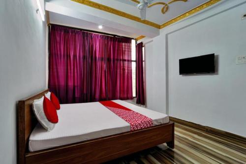a bedroom with a bed with a red curtain at Hotel Mahal Inn in Patna
