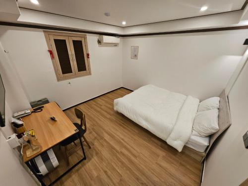 a small bedroom with a bed and a table at Hotel Jeong Ansan Seonbu in Ansan