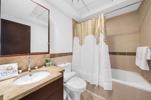 a bathroom with a sink and a toilet and a tub at Luxury Studio, 29 Boulevard Burj Khalifa Downtown - Chalet Homes in Dubai