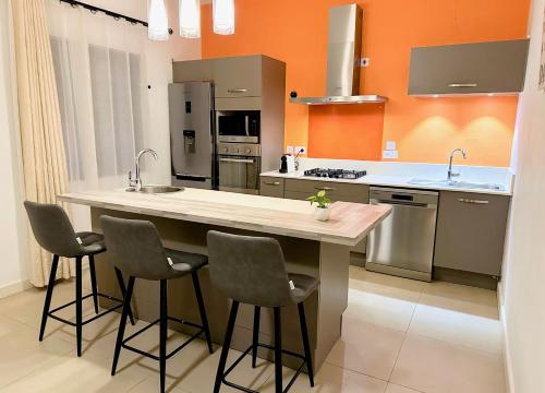 a kitchen with a large island with four bar stools at Charming Villa with Private Pool in La Rotraite