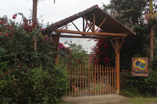 a wooden gate with a sign in a garden at Finca Agroturística El Portal in Gachetá