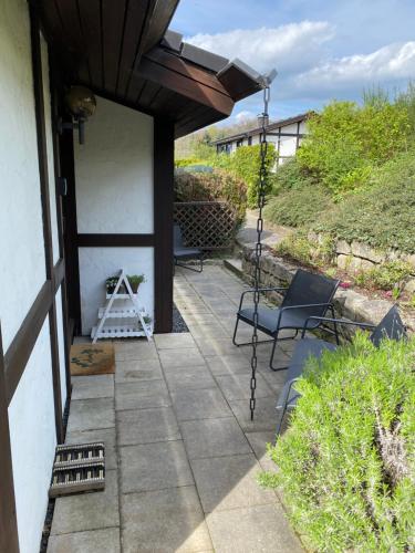 a porch with a swing and a chair at Henneliebe am Hennesee in Meschede