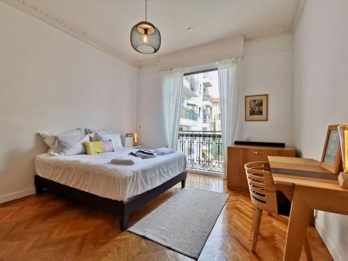 a bedroom with a bed and a desk and a window at Appartement Nice Bellecour in Nice