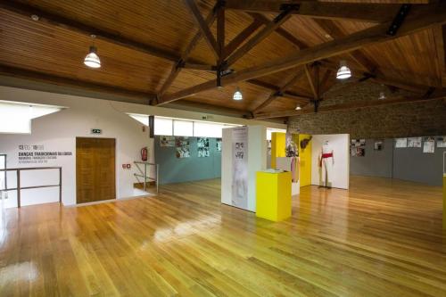 a large room with a wooden floor and exhibits at 3 Marias da Retirada in Lousa