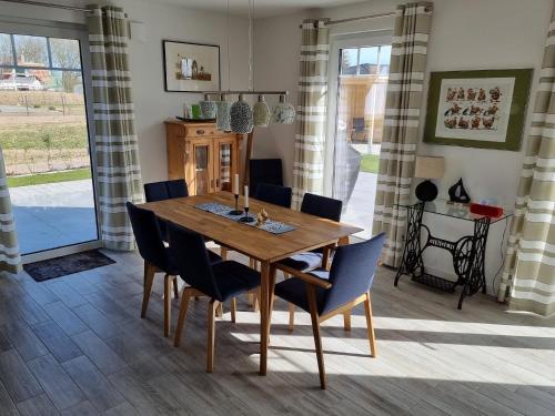 a dining room with a wooden table and chairs at Reethaus Edith im Süden der Insel Rügen am Naturschutzgebiet - Eine Auszeit für Körper und Seele in Mellnitz