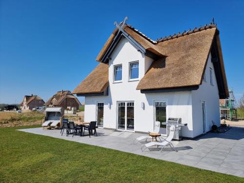 una gran casa blanca con techo en Reethaus Edith im Süden der Insel Rügen am Naturschutzgebiet - Eine Auszeit für Körper und Seele, en Mellnitz