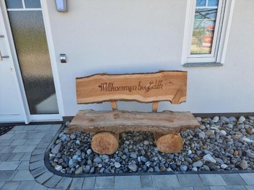 un banco de madera sentado frente a una casa en Reethaus Edith im Süden der Insel Rügen am Naturschutzgebiet - Eine Auszeit für Körper und Seele, en Mellnitz