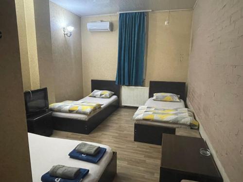 ein Zimmer mit 2 Betten und einem Stuhl darin in der Unterkunft Star Hotel in Rustawi