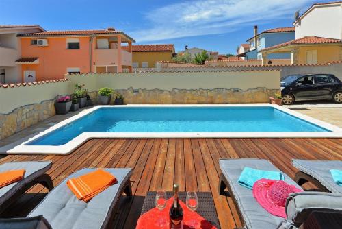 a swimming pool on a deck next to a house at Ferienhaus mit Privatpool für 6 Personen ca 80 qm in Barbariga, Istrien Istrische Riviera in Barbariga