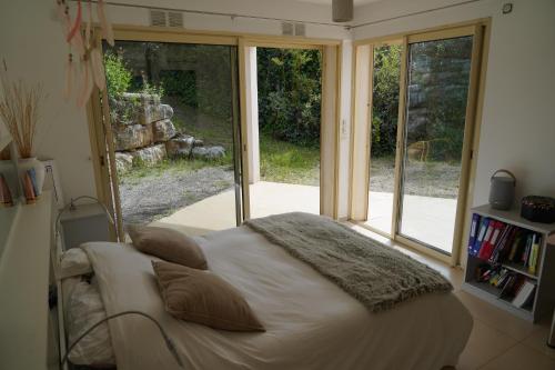 1 dormitorio con 1 cama en una habitación con ventanas en Villa de standing chambres climatisées avec piscine et jardin privatifs, en Biot